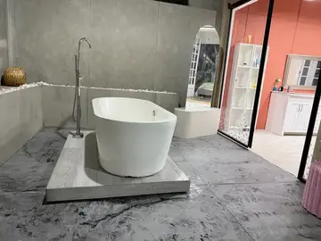 Baño de Loft 3 con tina independiente blanca, concreto y mobiliario de color