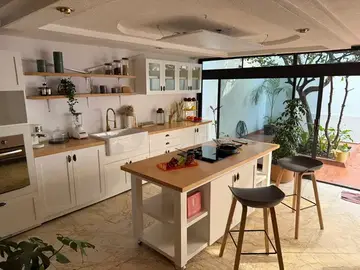 Cocina de Casa Santa Mónica con isla central de madera y vista al patio