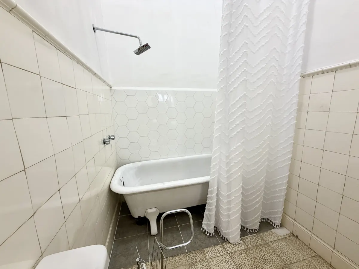 Baño de Casa Popotla con tina de patas y azulejos blancos