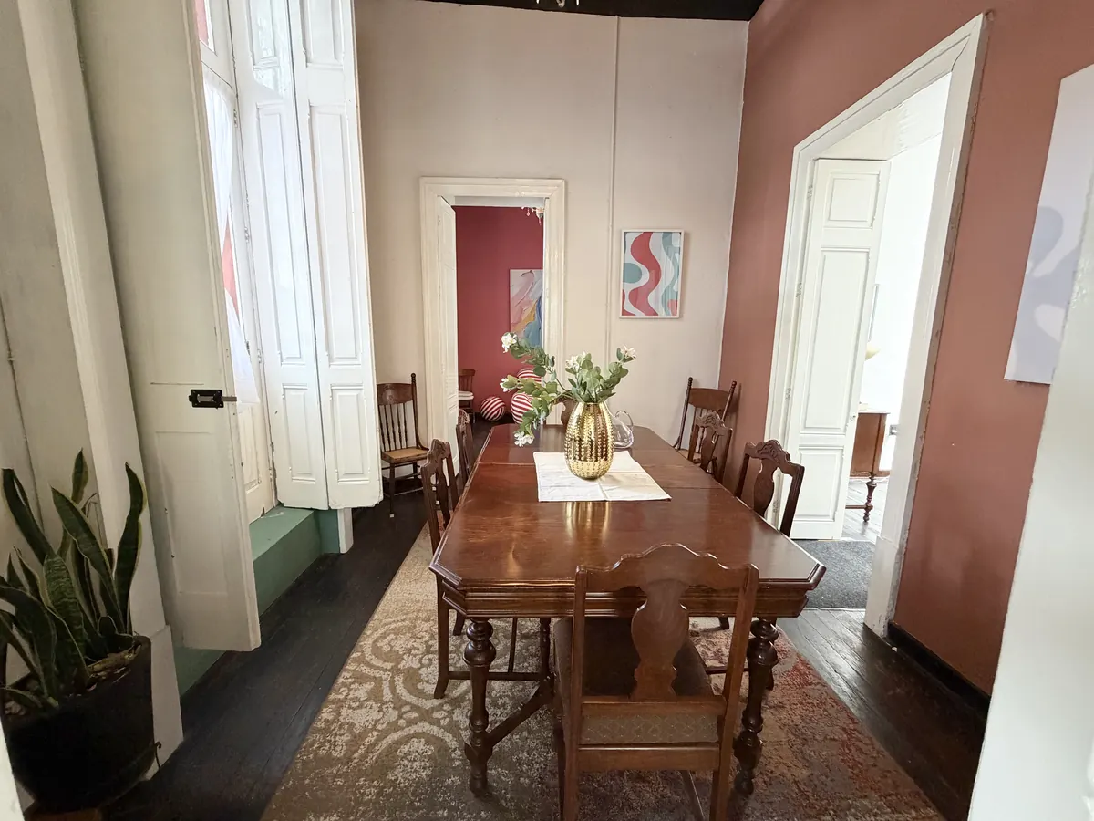 Comedor de Casa Popotla con mobiliario de madera y ventana alta